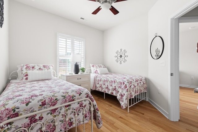 bedroom with visible vents, ceiling fan, baseboards, and wood finished floors