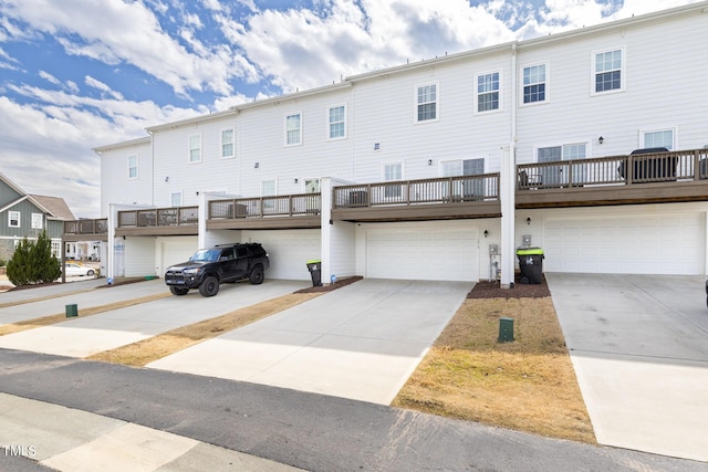 back of property featuring a residential view, an attached garage, and driveway