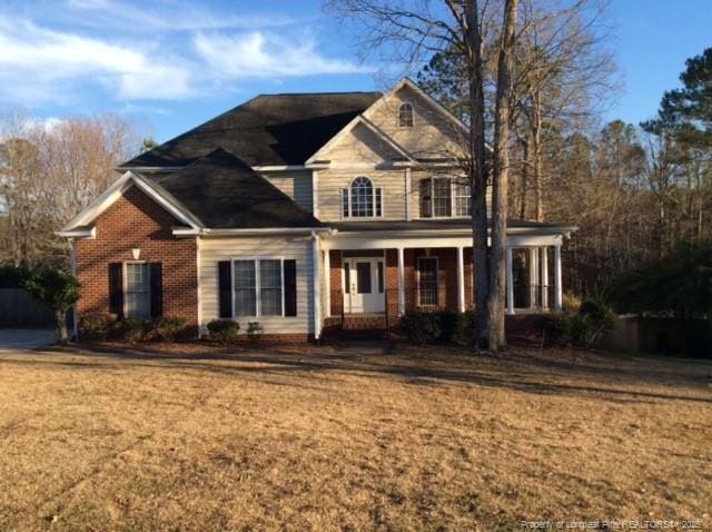 traditional home featuring brick siding and a front yard