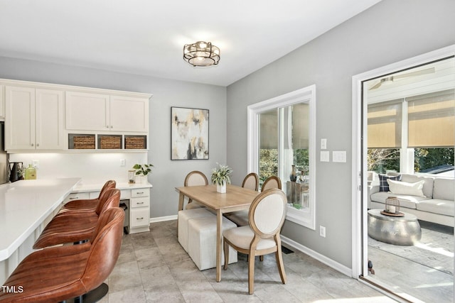 dining room featuring built in study area, plenty of natural light, and baseboards