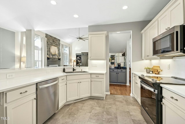 kitchen with ceiling fan, recessed lighting, stainless steel appliances, a sink, and light countertops