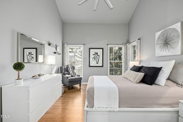 bedroom featuring a ceiling fan, light wood-type flooring, and multiple windows