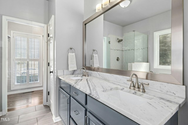 bathroom with double vanity, a sink, and a shower stall