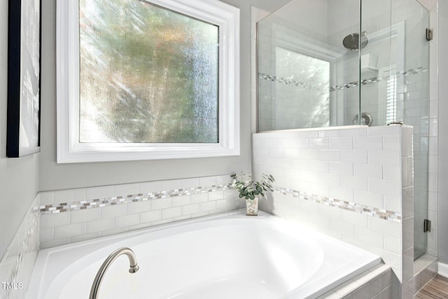 full bath with a stall shower and a garden tub