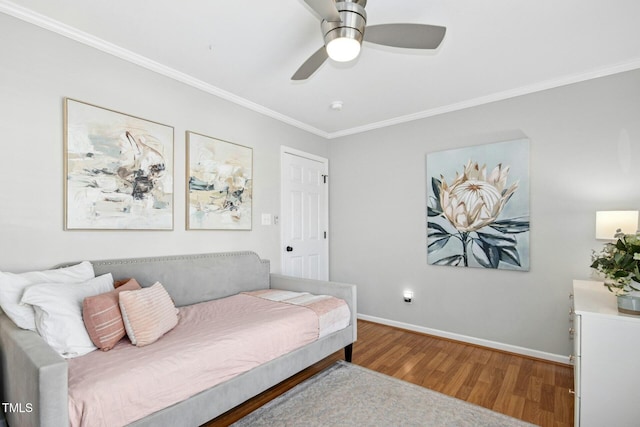 bedroom featuring ceiling fan, ornamental molding, wood finished floors, and baseboards