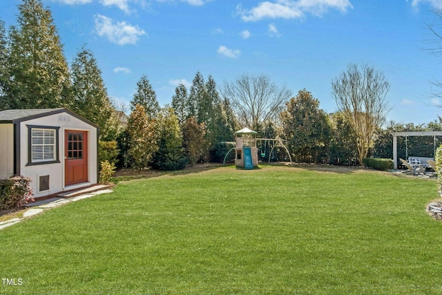 view of yard with a storage unit, a playground, and an outbuilding