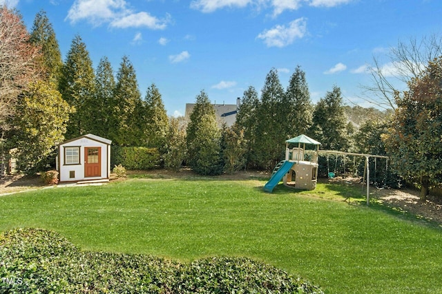 view of yard featuring a storage unit and a playground