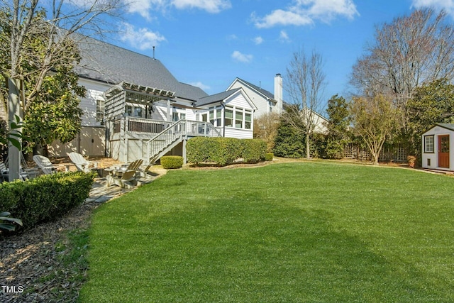 view of yard featuring a patio, stairway, an outbuilding, fence, and a pergola