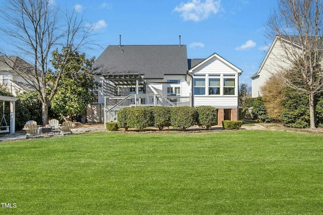 rear view of house featuring a wooden deck, a shingled roof, a pergola, and a yard