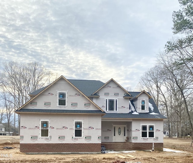 unfinished property featuring a porch and brick siding