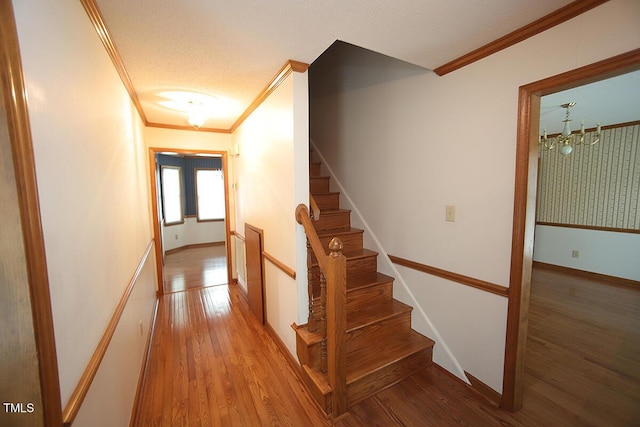 stairs featuring ornamental molding, baseboards, and wood finished floors