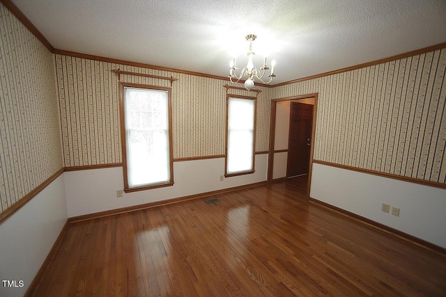 spare room with a wainscoted wall, hardwood / wood-style floors, and wallpapered walls