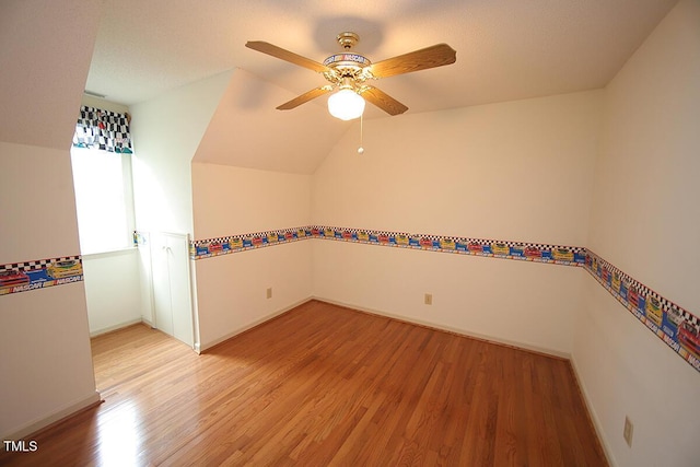 additional living space featuring lofted ceiling, ceiling fan, light wood finished floors, and baseboards