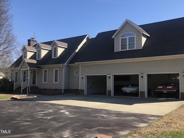 new england style home with concrete driveway, a shingled roof, crawl space, and an attached garage