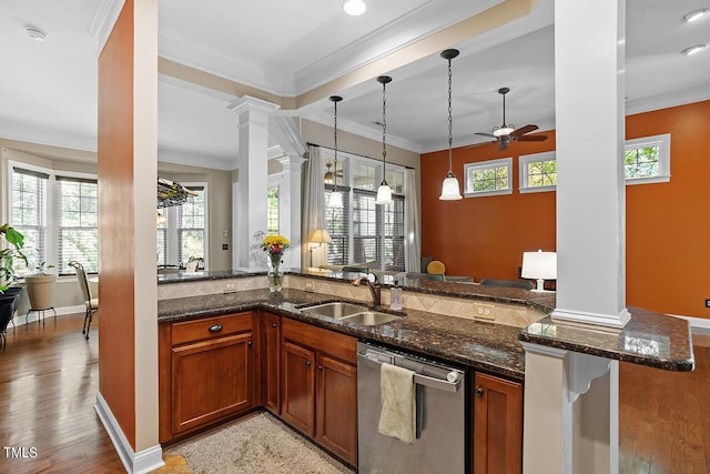 kitchen with a sink, decorative columns, crown molding, and dishwasher