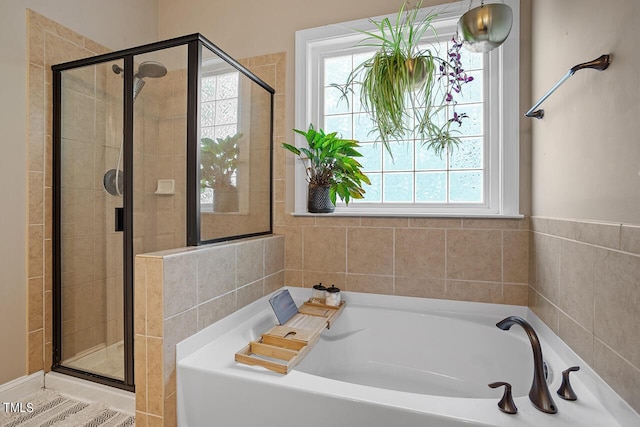 full bathroom with a shower stall and a bath