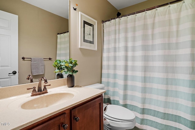 bathroom with curtained shower, vanity, and toilet