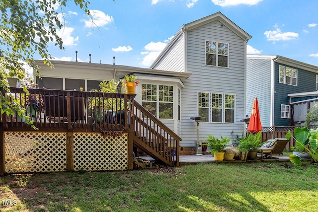 back of property with a sunroom, a yard, stairway, and a wooden deck