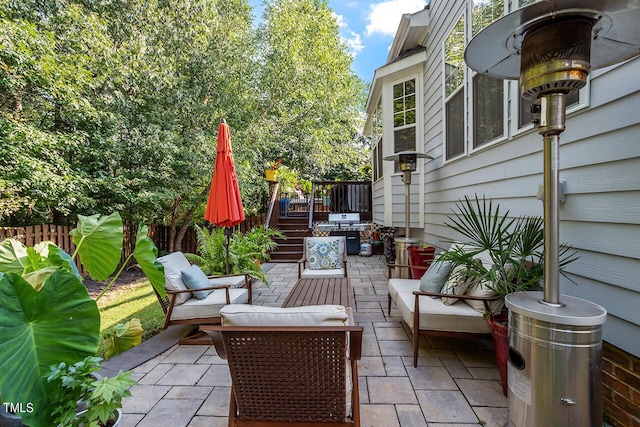 view of patio featuring grilling area, fence, an outdoor living space, and a wooden deck