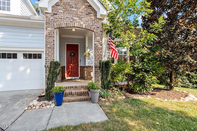 doorway to property featuring a garage and brick siding