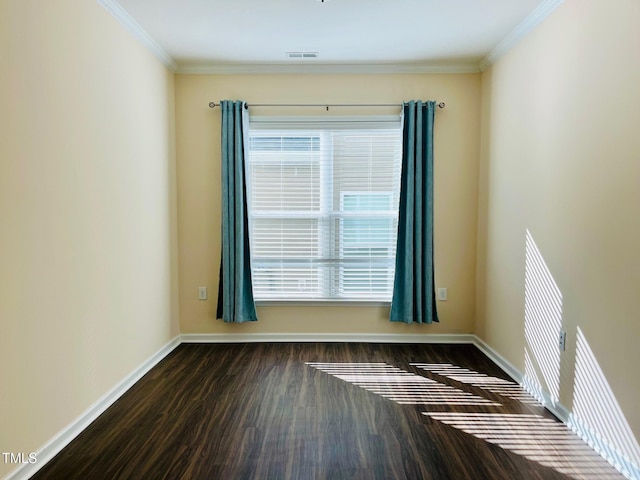 empty room with visible vents, crown molding, baseboards, and wood finished floors