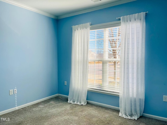 carpeted spare room with ornamental molding, visible vents, and baseboards