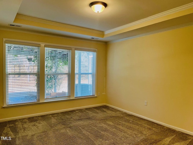 unfurnished room with crown molding, a raised ceiling, dark carpet, and baseboards