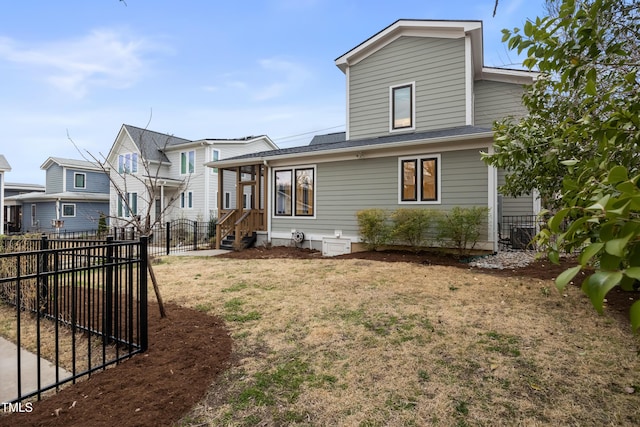 view of front of house with a gate, fence, and a front lawn