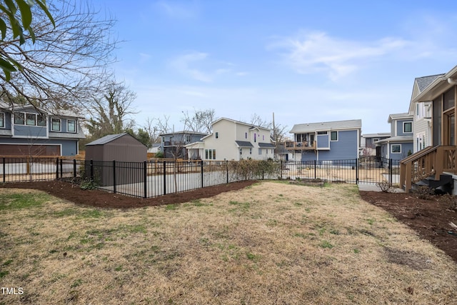 view of yard with a residential view, a fenced backyard, and an outdoor structure