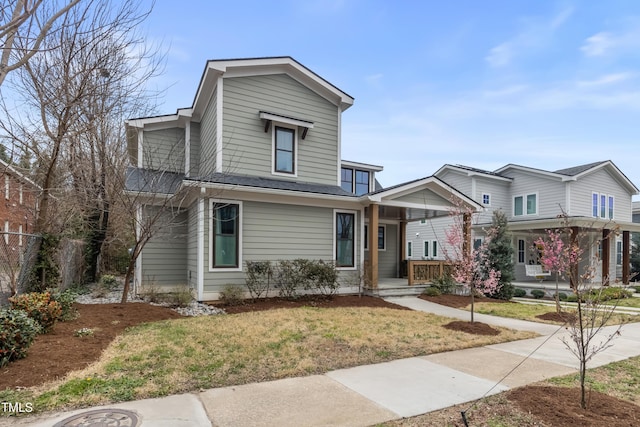 view of front facade featuring fence, a porch, and a front yard