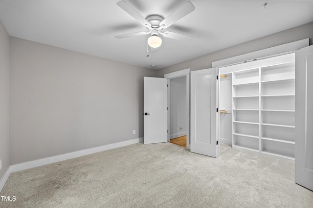 unfurnished bedroom featuring carpet floors, ceiling fan, baseboards, and a closet