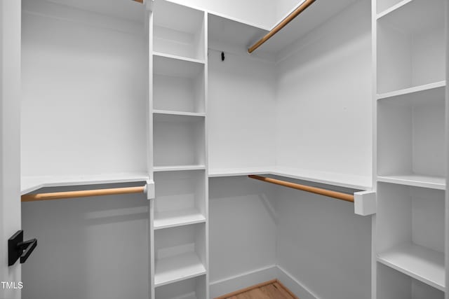 walk in closet with wood finished floors