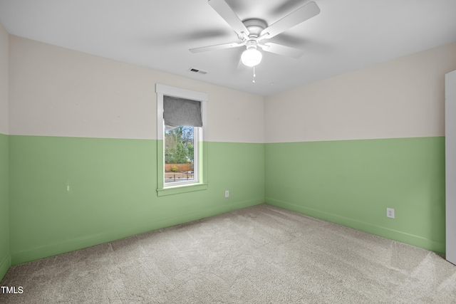 spare room with ceiling fan, carpet, and visible vents