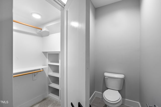 bathroom with baseboards and toilet