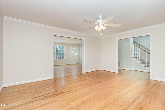 unfurnished room featuring crown molding, baseboards, stairs, and light wood-style floors