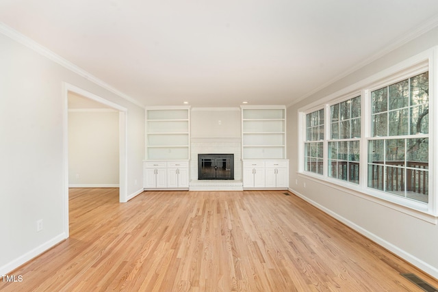 unfurnished living room with a healthy amount of sunlight, baseboards, visible vents, and ornamental molding