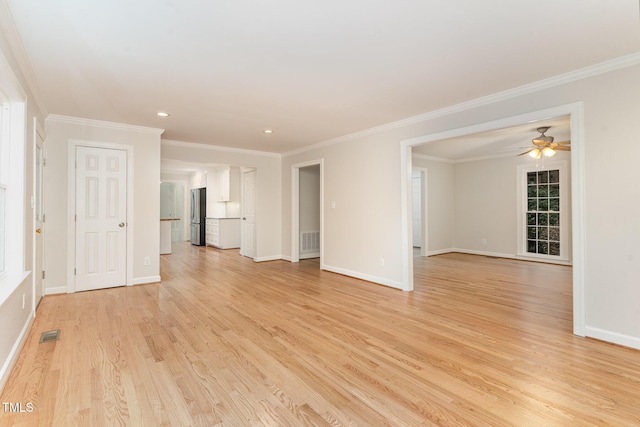 spare room featuring baseboards, visible vents, light wood finished floors, and ornamental molding