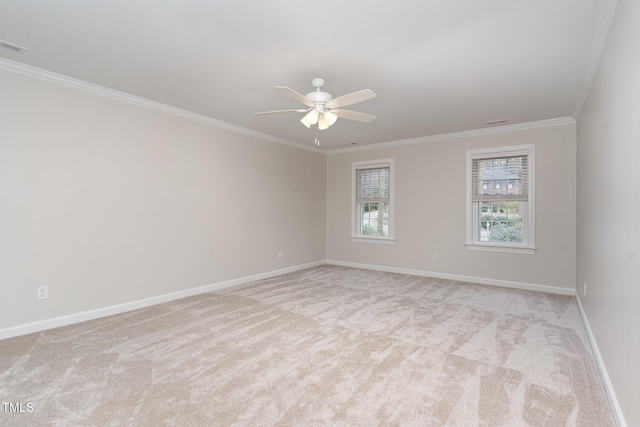 empty room with visible vents, baseboards, ceiling fan, light carpet, and crown molding