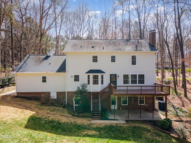 rear view of house with stairs, a patio, a lawn, and a chimney