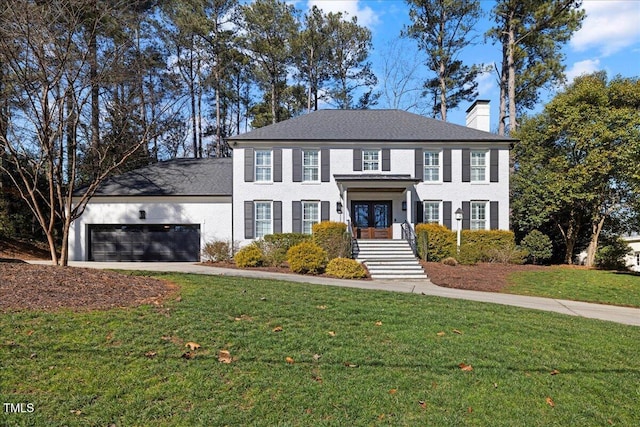 view of front of home featuring a garage, a chimney, a front lawn, and concrete driveway