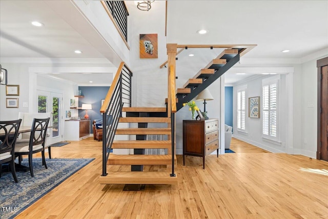 stairway with baseboards, ornamental molding, wood finished floors, french doors, and recessed lighting