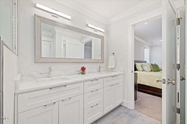 ensuite bathroom featuring ornamental molding, double vanity, a sink, and ensuite bathroom