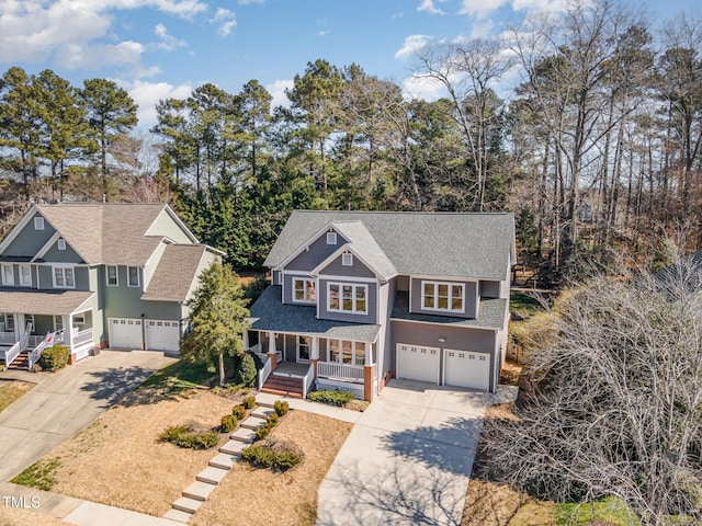 view of front facade with an attached garage, a shingled roof, a porch, and concrete driveway