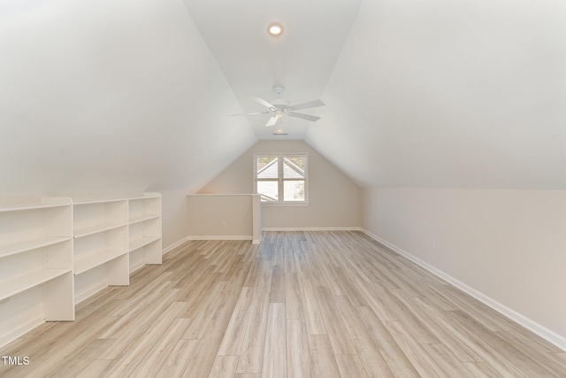 bonus room with vaulted ceiling, light wood-style flooring, and baseboards