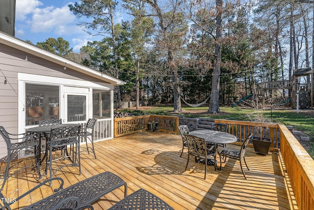 wooden deck featuring a sunroom and outdoor dining area