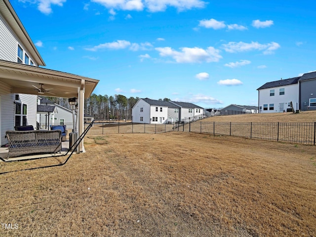 view of yard featuring a ceiling fan, a residential view, and a fenced backyard