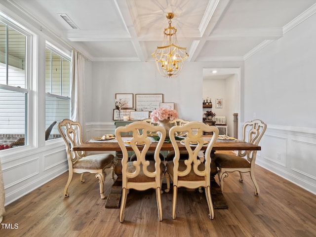 dining area featuring a notable chandelier, coffered ceiling, wood finished floors, visible vents, and beam ceiling