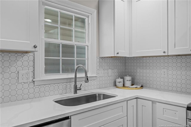 kitchen with white cabinetry, a sink, and decorative backsplash