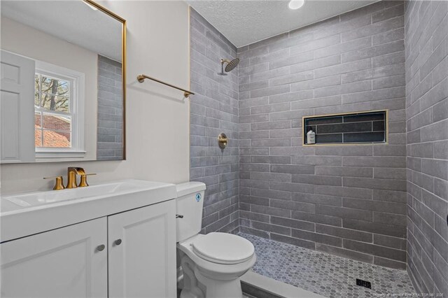 6815 Radial Dr, Fayetteville, NC 28311 - bathroom featuring vanity, a tile shower, and a textured ceiling