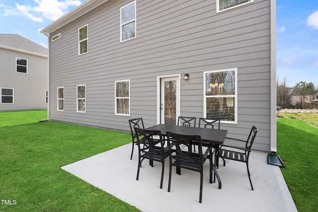 rear view of house with a yard, outdoor dining area, and a patio